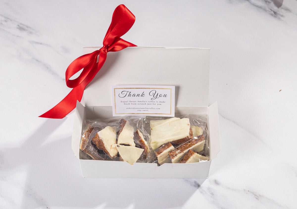 Sweet Amelia's 1/2 lb toffee box open, showing two bags of toffee and a thank-you card