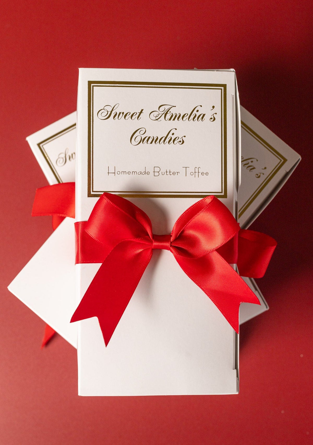 Stacked 1/2 lb toffee boxes with red satin bows