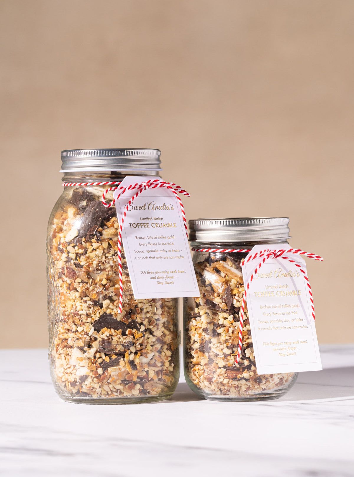 Two glass jars of Sweet Amelia's toffee crumble, small and large